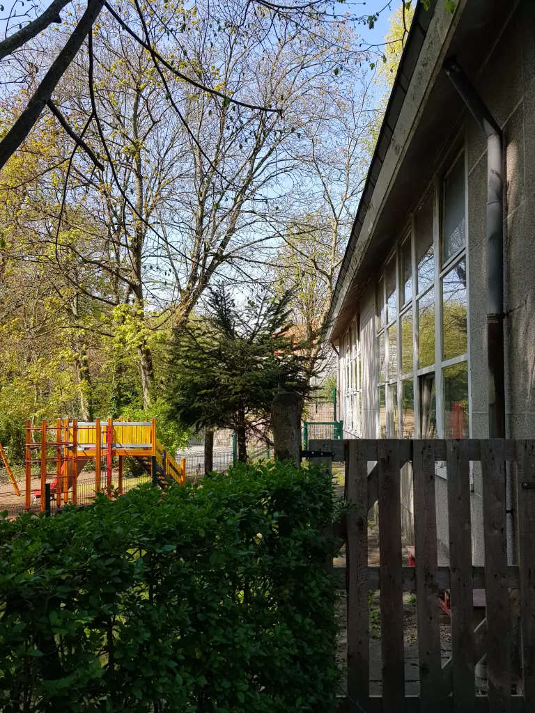 Portillon en bois entre les haies, vers l’aire de jeux