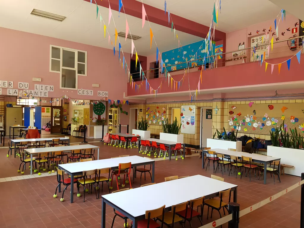 Grande salle à mezzanine décorée de fanions, avec des tables