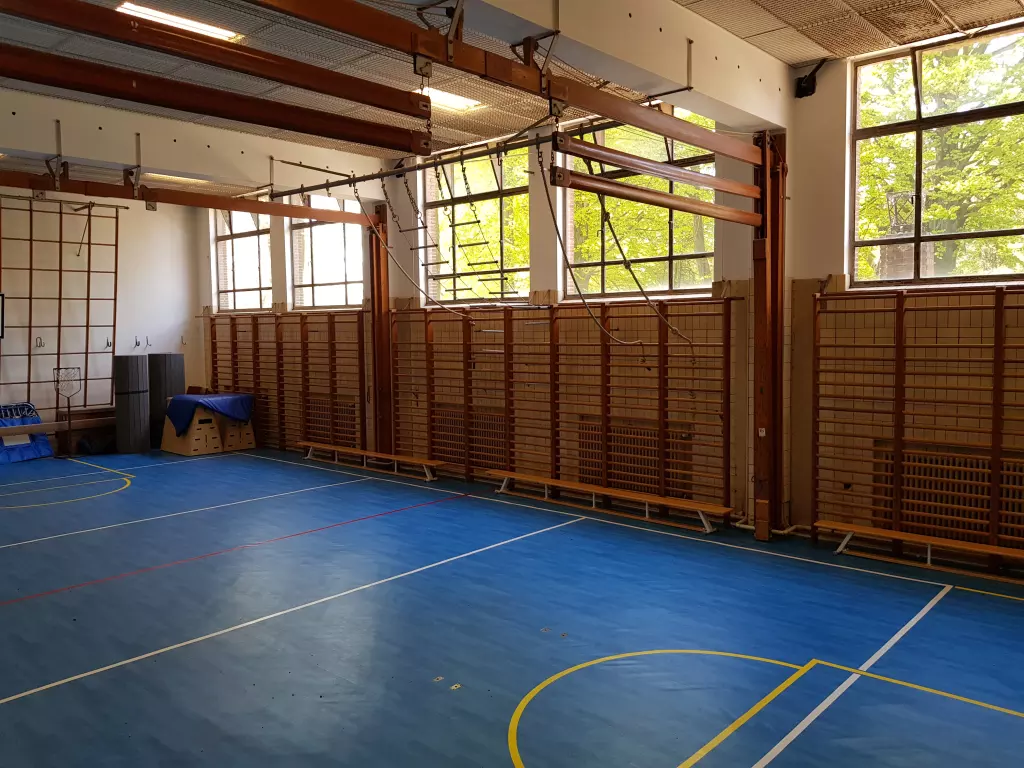 Salle de gymnastique avec des espaliers et un sol bleu