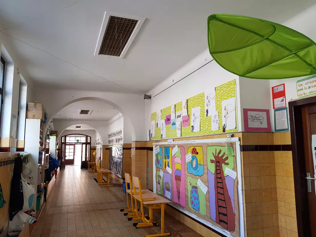 Couloir décoré de dessins d’arbres réalisés par les élèves