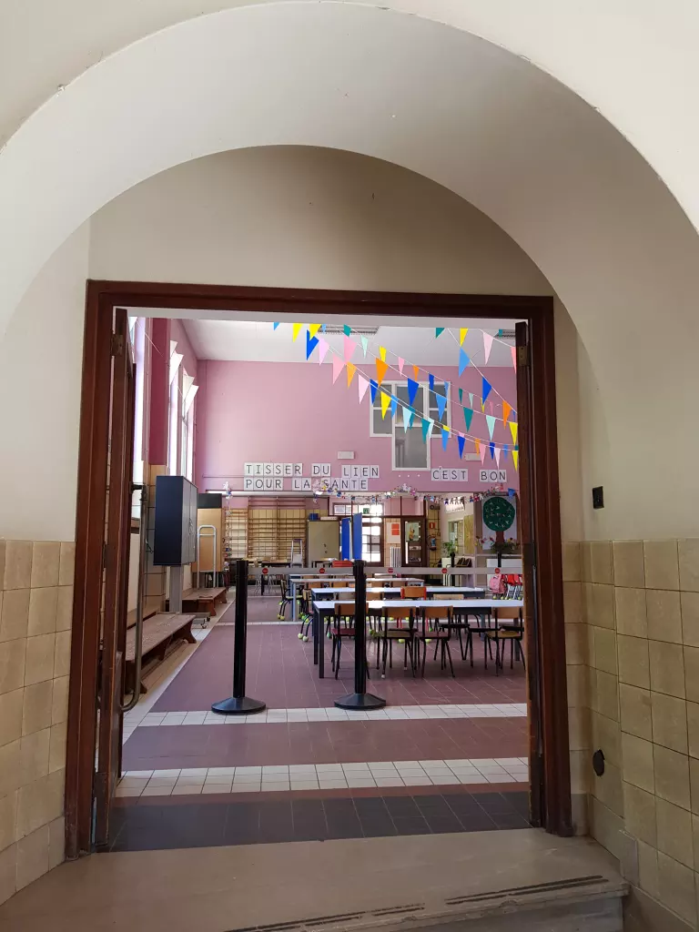 Porte en arc ouvrant sur la grande salle décorée de fanions
