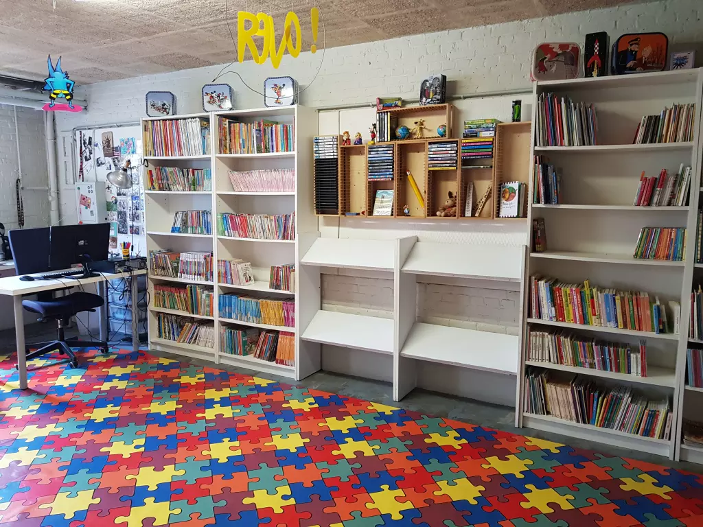 Bibliothèque de l’école, avec ses rayonnages de livres et un coin ordinateur