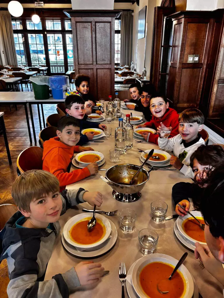 Des élèves partagent un repas autour d’une grande table