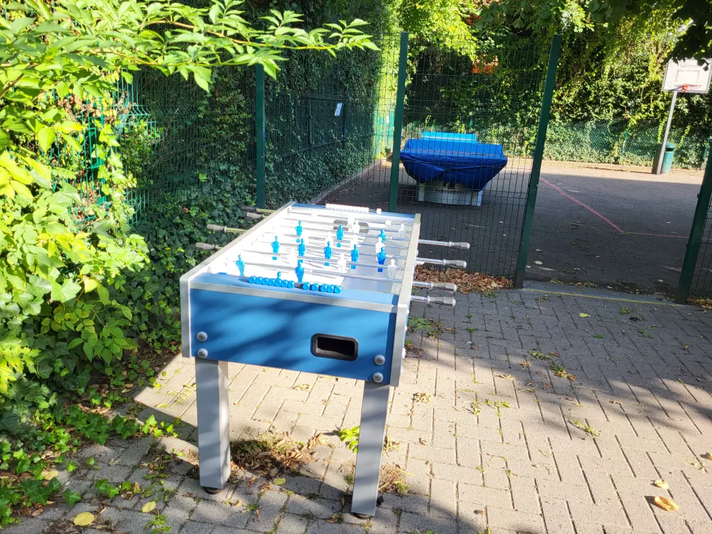 Baby-foot et table de ping-pong d’extérieur dans un coin de la cour