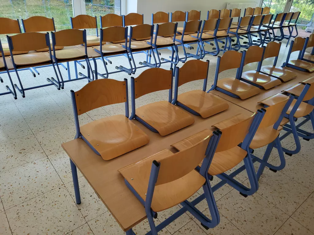 Salle avec des rangées de tables et de chaises en bois
