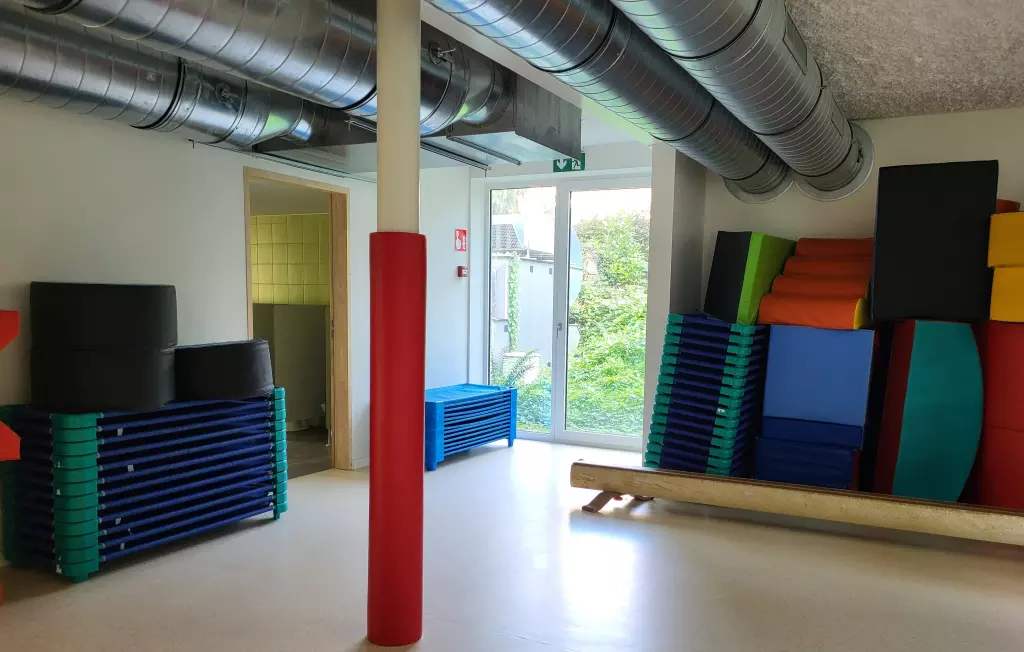 Tapis et blocs de mousse colorés rangés dans la salle de motricité